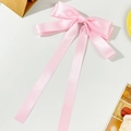 Elegante roze satijnen haarstrik met lange linten op een schone esthetische achtergrond - Roze
