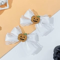 Detailansicht der Halloween-Schleifen-Haarklammer mit glitzerndem Kürbis auf weißer Spitze - Weißer Spitzenstil