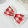 Detail of a vintage red houndstooth bow hair clip with delicate white lace trim - Red