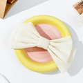 Vista detallada de un pasador de pelo con lazo crema y textura acanalada en un plato - Lazo Pequeño de Doble Capa (1#) / crema