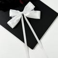 Elegant white satin bow hair clip with lace trim and long ribbons on minimalist background - White