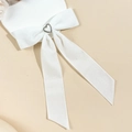 Nahaufnahme einer weißen Satin-Schleife mit einem Herz-Strass-Detail für elegante Frisuren - Weiß