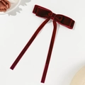 Dettaglio del fiocco per capelli in velluto rosso scuro con nastri lunghi e consistenza fine - Borgogna