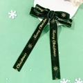 Detail von dunkelgrüner Samtschleife mit goldenem Merry Christmas Aufdruck und Sternen - Haarspangen-Stil / Weihnachtsgrün