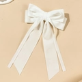 Detalle de elegante lazo para el pelo en satén blanco con cintas largas sobre fondo liso - Blanco