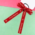 Detail of red velvet Christmas bow hair tie with golden Merry Christmas sequins - Elastic Band Style / Red