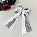 Detail of Gothic Lolita bow clip with white satin layers and black lace with heart gem - White Cross Pendant Style