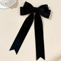 Detail van elegante zwarte fluwelen haarklem met lange linten op minimalistische basis - Zwart