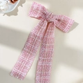 Detailstruktur der rosa Tweed Schleifen-Haarspange mit goldfarbenen Fäden und Fransen - Rosa