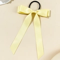 Detail of light yellow satin bow hair tie with long ribbons on a neutral background - Yellow