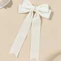Detail van elegante crème fluwelen harikstrik met lange linten en een zwaluwstaartvormig uiteinde - Beige