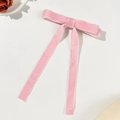 Detail of soft pink velvet bow hair clip with long ribbons on a white background - Pink