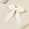 Close-up of elegant white velvet bow hair clip with long ribbons on beige background - Beige