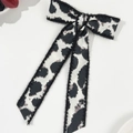 Detailed view of leopard print bow hair clip with long ribbons on white surface - Cow Print (Spring Clip-Long Streamer)
