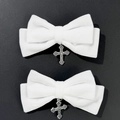 Close-up of white velvet bow hair clips with gothic silver cross pendants on black background - White