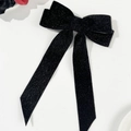 Detalle de un lazo para el pelo de terciopelo negro con purpurina y cintas colgantes - Negro