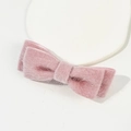 Detailed close-up of a soft pink plush bow hair clip with fluffy faux fur texture - Pink