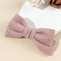 Detailed macro view of a soft pink plush bow hair clip with faux mink fur texture - Pink