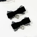 Dettaglio di fermagli in velluto nero con pizzo e ciondoli a cuore con croce stile gothic - Nero