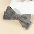 Detail view of a gray plush bow hair clip featuring soft texture and fine fuzzy material - Gray