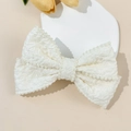 Dettaglio dell'elegante fermaglio per capelli a fiocco bianco con perle decorative - Beige