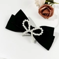 Elegante fermaglio per capelli in velluto nero con fiocco di perle retrò su fondo bianco - Nero