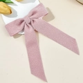 Detail der rosa Plüsch-Schleifen-Haarklammer mit weicher Textur und langen Bändern - Rosa