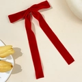 Eleganter Happerclip aus rotem Samt mit langen Bändern auf beigem Hintergrund - Rot
