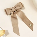 Nahaufnahme der braunen Cord-Schleifenspange mit goldenem Strass-Buchstaben A - Khaki