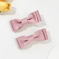 Close-up of dual corduroy bow hair clips in dusty rose pink with ribbed texture details - Pink