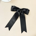 Detail of elegant black satin bow hair clip with long ribbons and smooth silky texture - Black