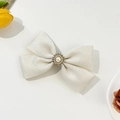 Dettaglio del fermaglio per capelli a fiocco bianco crema con perla e strass fini - Bianco