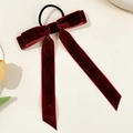 Close-up of wine red velvet bow hair tie with long ribbons on a beige background - Burgundy