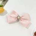 Pink ribbon bow hair clip with pearl rhinestone center on a clean white background - Pink