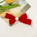 Elegant red velvet bow hair clip with white faux pearl decoration on cream background - Red