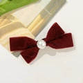 Detail of burgundy velvet bow hair clip featuring a centered white pearl decoration - Burgundy