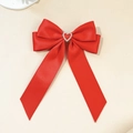 Vista macro di un fiocco di raso rosso con una decorazione a cuore di cristallo lucido - Rosso