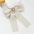 Dettaglio del fiocco in tessuto a spina di pesce con girasole di perle e piccoli strass - Bianco