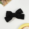 Detailed macro view of a black sequined tweed bow hair clip with vintage texture - Black