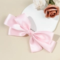 Detail view of the soft light pink satin fabric and tiered structure of the bow hair clip - Pink