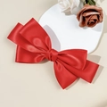 Detail of red satin layered bow hair clip on elegant white plate with soft roses - Red