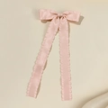 Nahaufnahme der rosa Satin-Haarspange mit Rüschenkanten und langen fließenden Bändern - Rosa