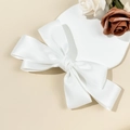 Detailed side view of a white multi-layered satin bow hair clip on a soft cream background - White