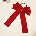 Detalle de un coletero de terciopelo rojo oscuro con lazo y cintas largas elegantes - Rojo