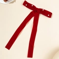Detail of red velvet bow hair clip with faux pearl embellishments and elegant ribbons - Red