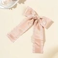 Nahaufnahme der rosa Satin-Haarspange mit Rüschenkanten und langen Bändern - Rosa