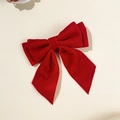 Détail de la texture velours fine et de la barrette nœud rouge à double couche - Rouge