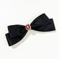 Dettaglio di un elegante fiocco di raso nero con una pietra preziosa rossa - Nero