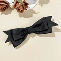 Detailed close-up of a black satin ribbon hair clip with elegant swallowtail design - Black