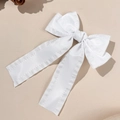 Nahaufnahme einer weißen Satin-Schleife Haarspange mit eleganten Bändern und feiner Naht - Weiß
